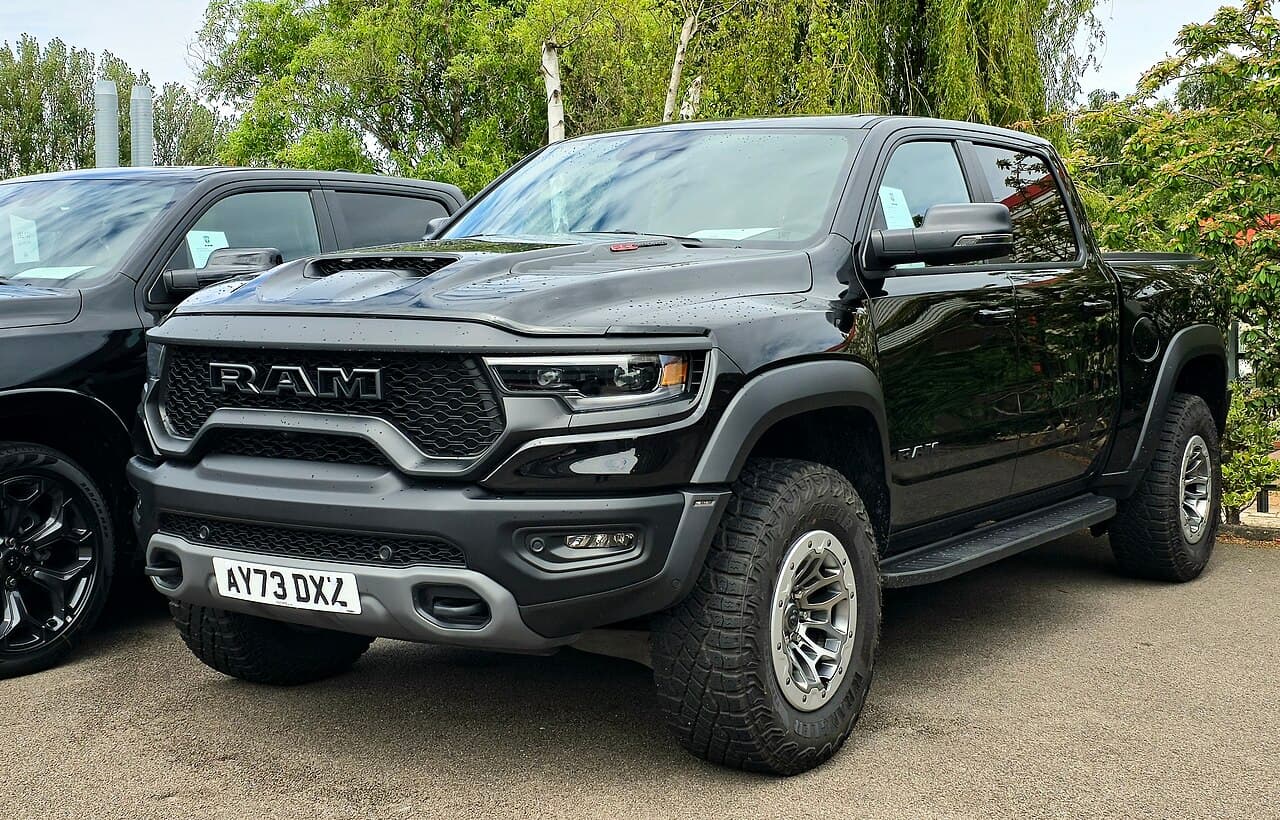 Front three-quarter view of a black Ram 1500 TRX on aftermarket bronze wheels at an outdoor UK car meet (file is mistitled 'HEMI' on Commons but the truck is a TRX).