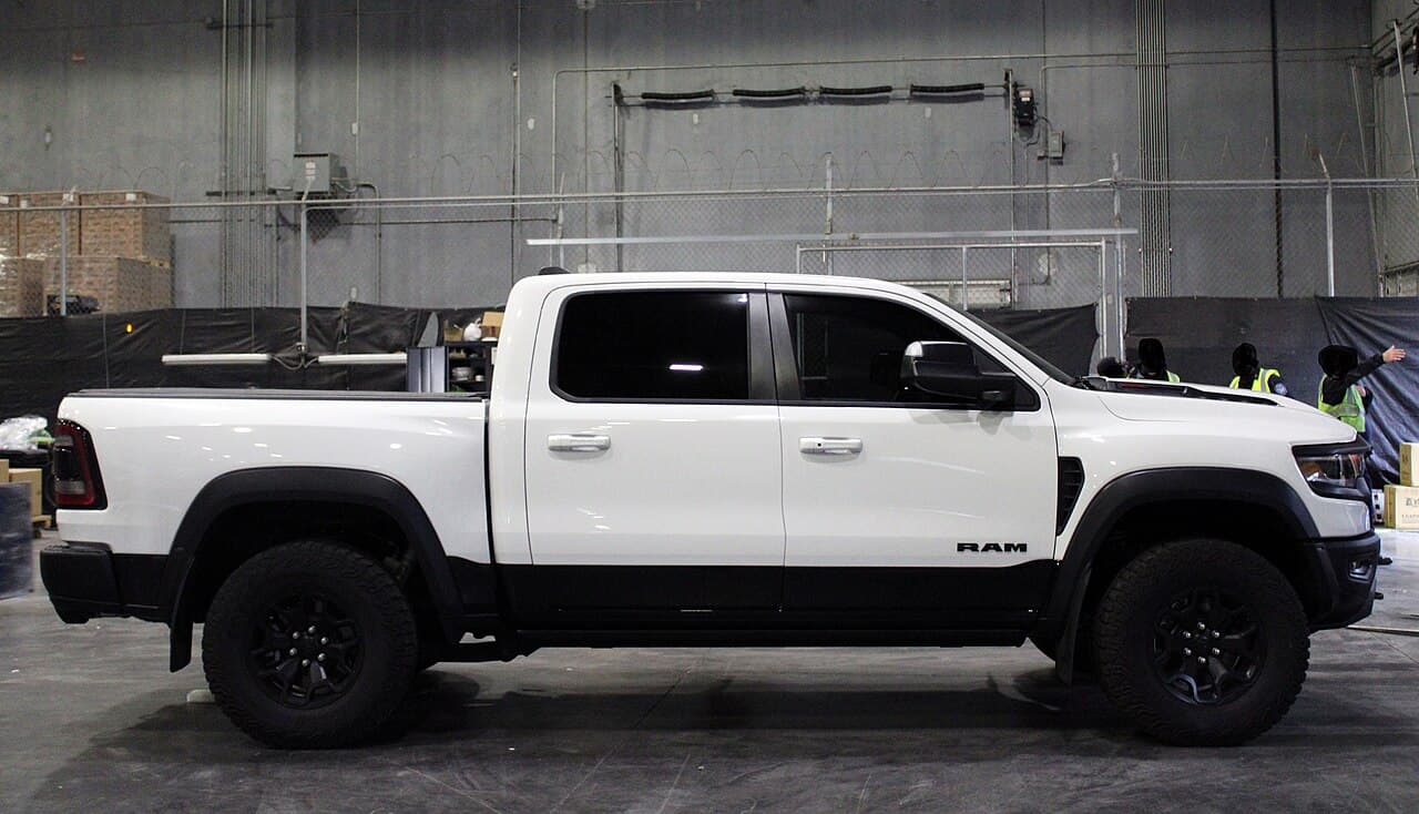 Side profile of a white Ram 1500 TRX inside a U.S. Customs and Border Protection warehouse after being recovered as a stolen vehicle at Charleston seaport.