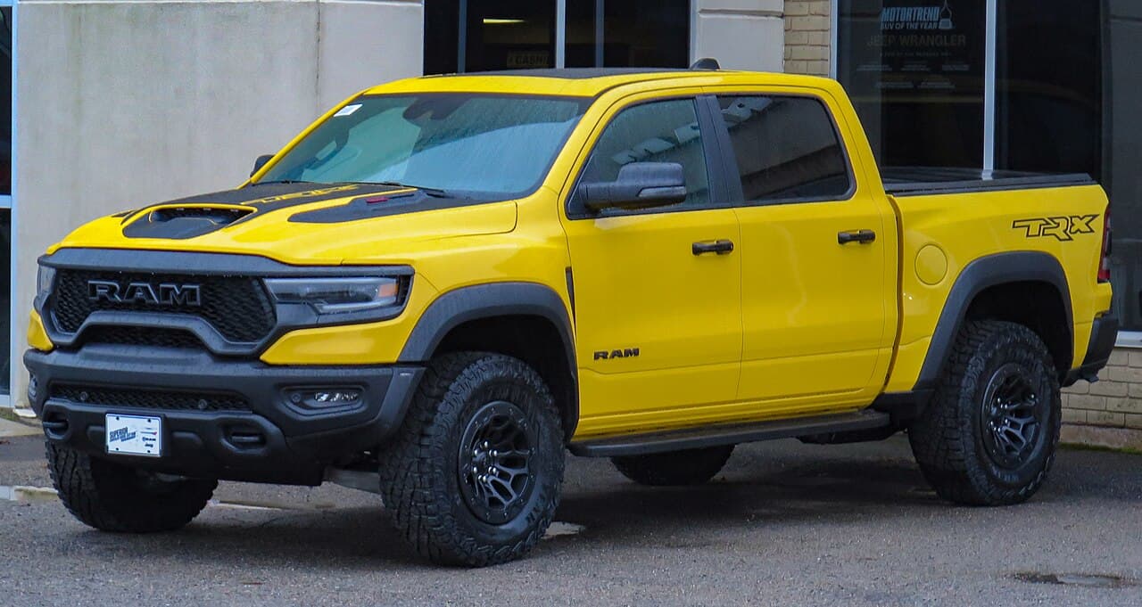 Front-left view of a Baja Yellow 2023 Ram 1500 TRX Havoc Edition parked at a dealership in Sault Ste. Marie, Ontario.
